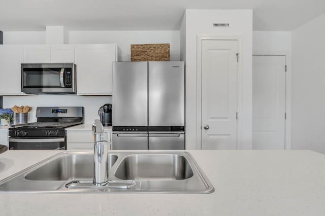 kitchen with white cabinetry, light countertops, and appliances with stainless steel finishes