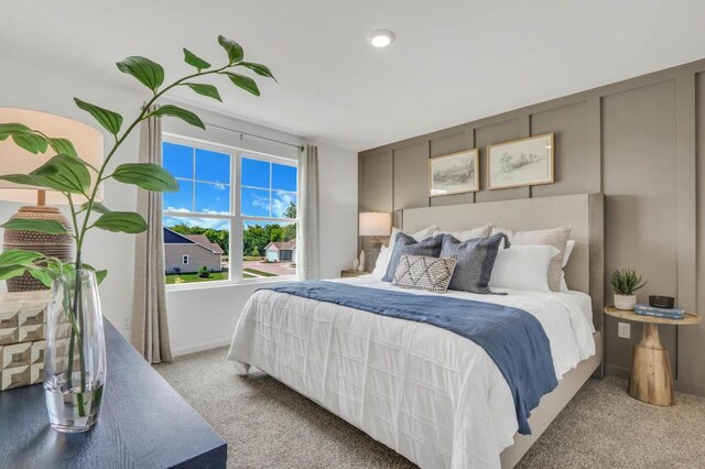 bedroom featuring light carpet and baseboards