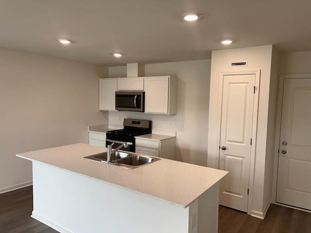 kitchen with stainless steel appliances, a sink, dark wood-style floors, visible vents, and white cabinets
