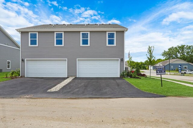 view of front of house with a garage, a front yard, and aphalt driveway