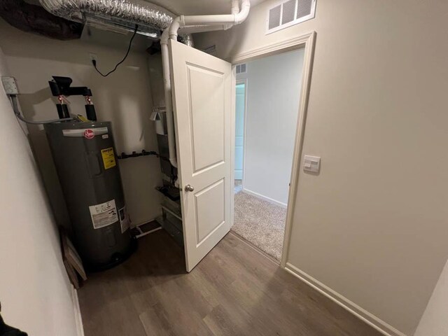 utility room featuring water heater and visible vents