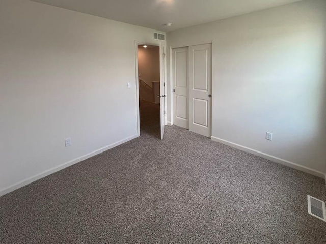 unfurnished bedroom with carpet flooring, baseboards, and visible vents