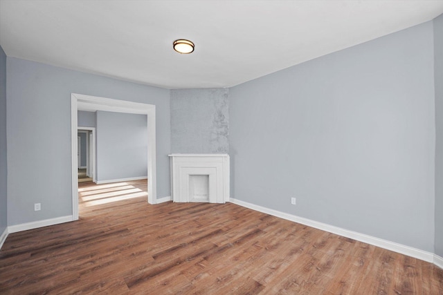 unfurnished room featuring baseboards and wood finished floors