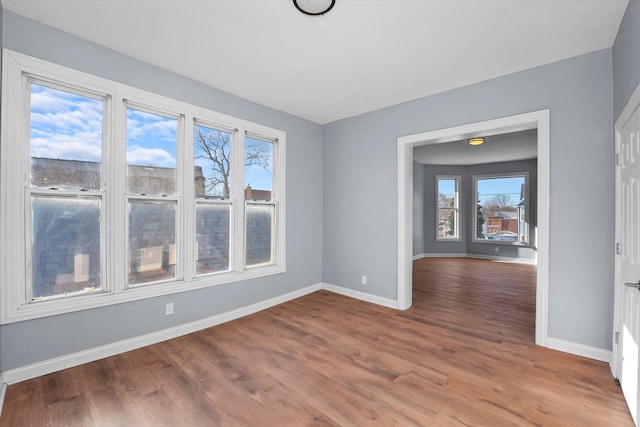 unfurnished room with baseboards and wood finished floors