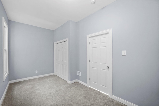 unfurnished bedroom featuring baseboards, a closet, and carpet floors