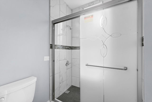bathroom featuring toilet and a stall shower