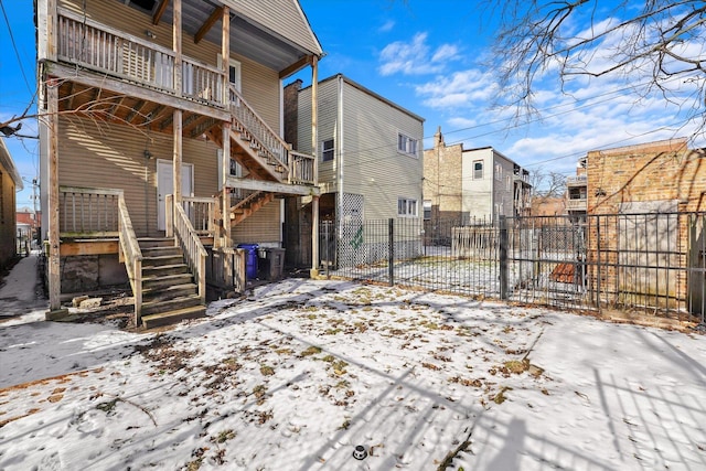 snow covered property with stairs and fence