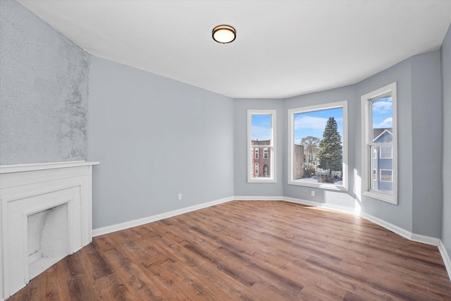 unfurnished living room featuring baseboards and wood finished floors