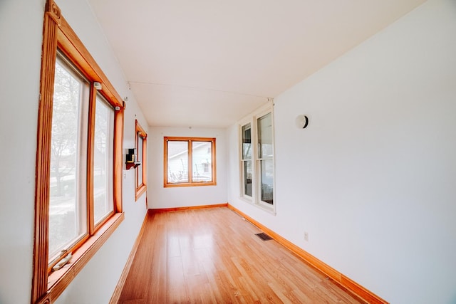 245 E 4th Ave, Clifton, IL 60927 - unfurnished sunroom featuring baseboards, visible vents, a healthy amount of sunlight, and wood finished floors