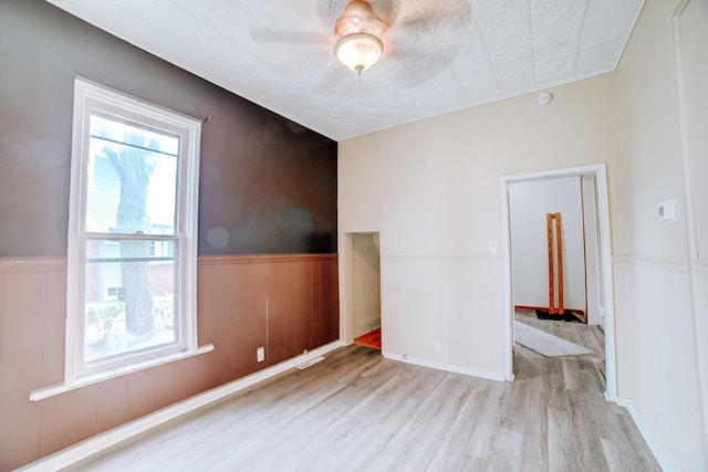 245 E 4th Ave, Clifton, IL 60927 - unfurnished room featuring light wood-type flooring, wainscoting, ceiling fan, and visible vents