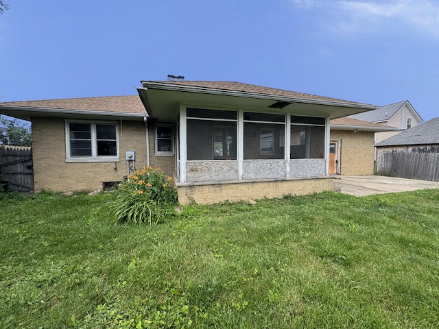 321 1st St, Bradford, IL 61421 - back of property featuring a sunroom, brick siding, and a patio area