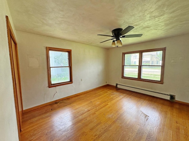 321 1st St, Bradford, IL 61421 - spare room with a baseboard radiator, plenty of natural light, light wood-style flooring, and ceiling fan