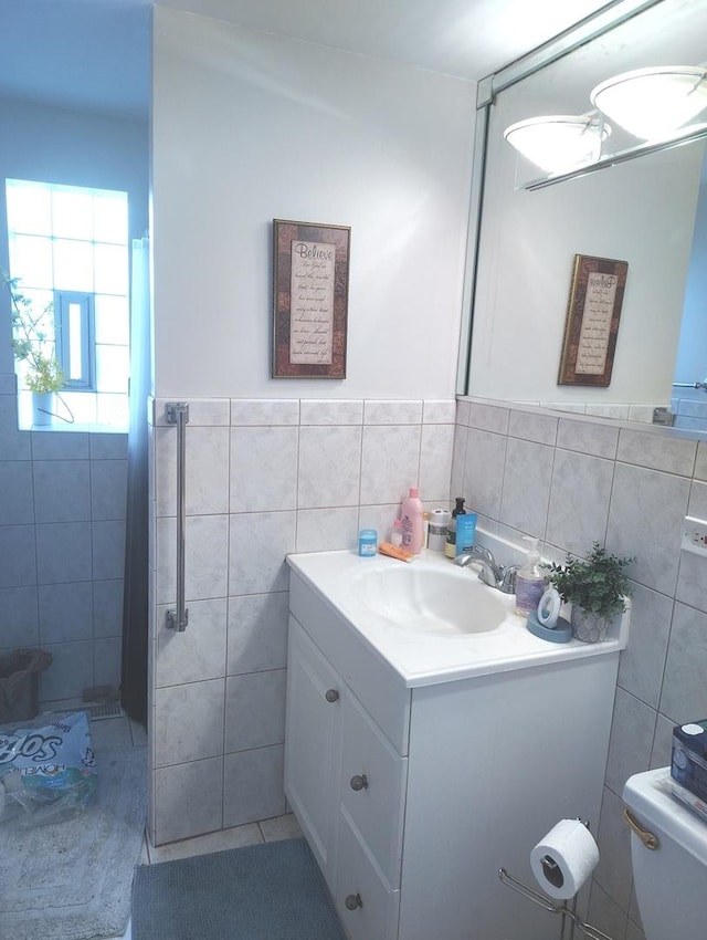8550 S Avalon Ave, Chicago, IL 60619 - bathroom featuring tile walls, toilet, vanity, a shower, and wainscoting