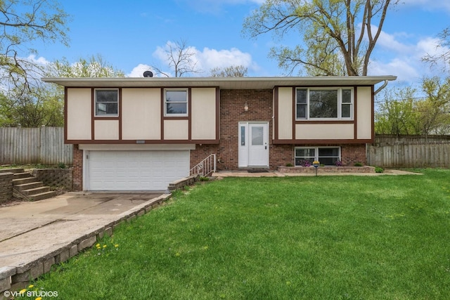 bi-level home with a garage, brick siding, fence, a front lawn, and concrete driveway