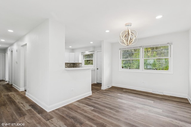 interior space featuring baseboards, recessed lighting, dark wood-style flooring, and a chandelier