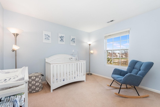carpeted bedroom featuring a nursery area, visible vents, and baseboards