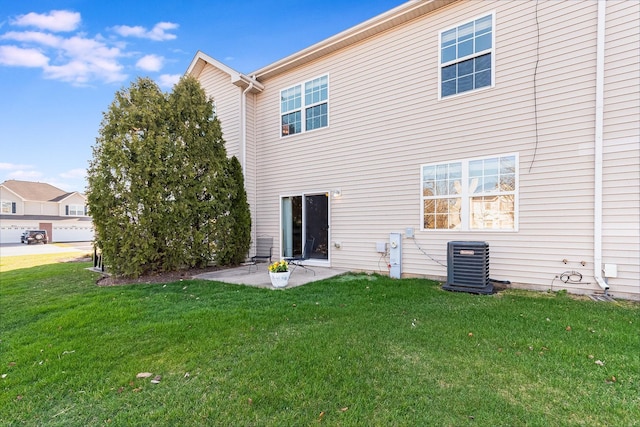 rear view of property with a yard, central AC, and a patio