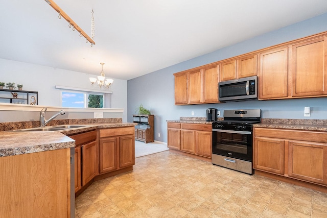 kitchen featuring a sink, a chandelier, pendant lighting, light floors, and appliances with stainless steel finishes