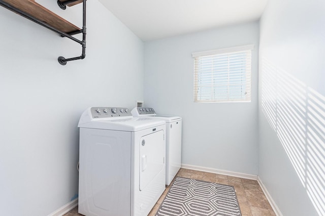 clothes washing area featuring washer and dryer, baseboards, and laundry area