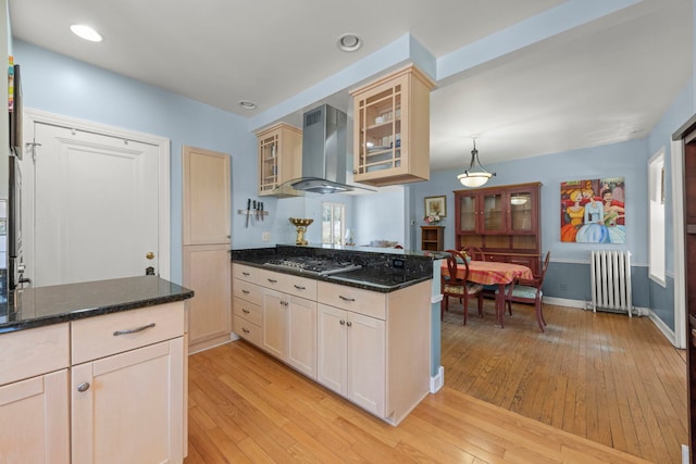 17864 Gladville Ave, Homewood, IL 60430 - kitchen with radiator, stainless steel gas stovetop, glass insert cabinets, wall chimney exhaust hood, and light wood-style flooring