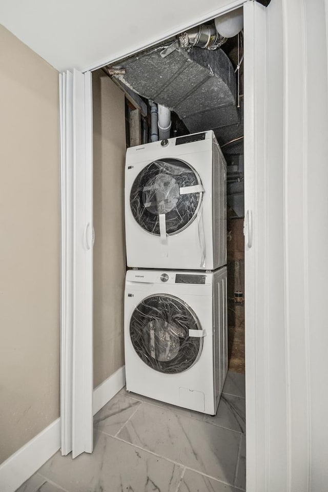 230 Dodge Ave Unit D, Evanston, IL 60202 - laundry area featuring marble finish floor, baseboards, stacked washer / dryer, and laundry area