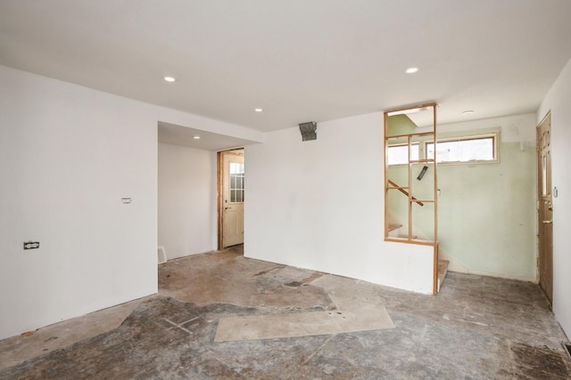 unfurnished room featuring recessed lighting and stairs