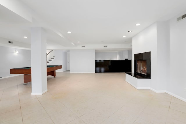 below grade area featuring visible vents, recessed lighting, a multi sided fireplace, and light tile patterned flooring