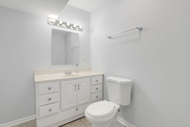 bathroom with vanity, toilet, baseboards, and tile patterned floors