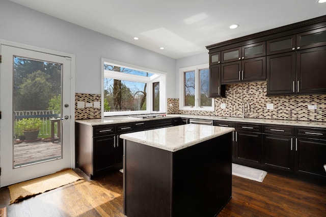 kitchen with stainless steel appliances, a center island, recessed lighting, decorative backsplash, and light stone countertops