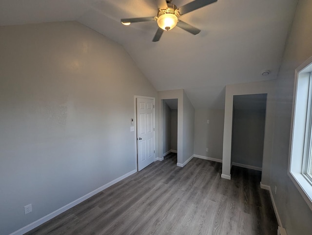 interior space featuring baseboards, lofted ceiling, and wood finished floors