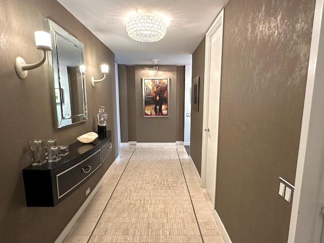 hall with a chandelier and light tile patterned flooring