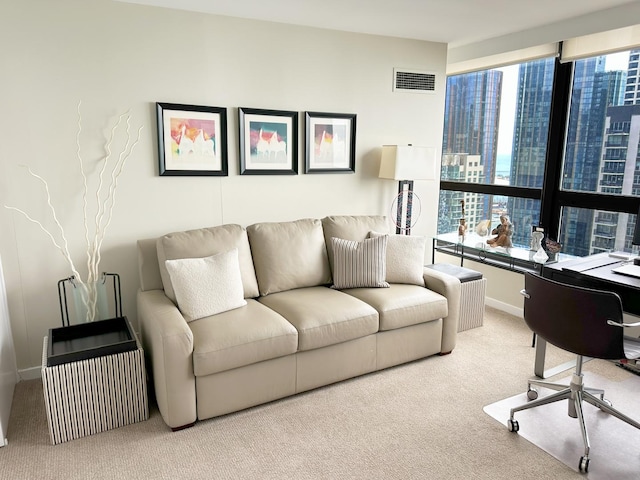 carpeted living area with healthy amount of natural light, baseboards, an office area, and a view of city