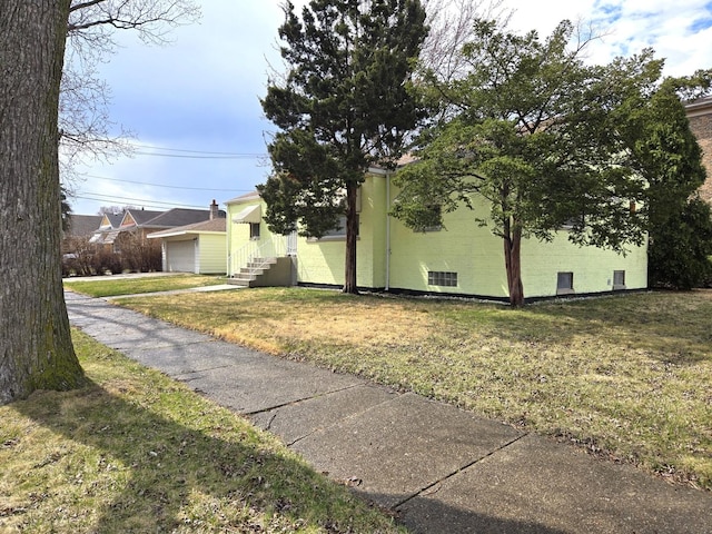 view of side of property featuring a yard and a detached garage