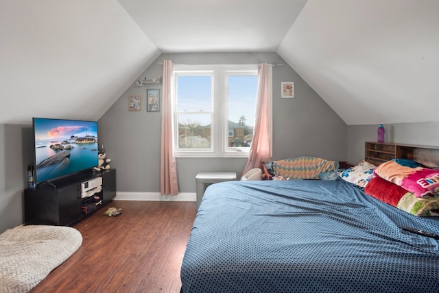 bedroom featuring lofted ceiling, wood finished floors, and baseboards