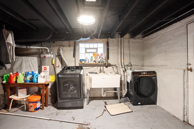 basement with gas water heater, a sink, and washer and clothes dryer
