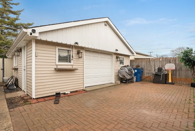 exterior space featuring decorative driveway and fence