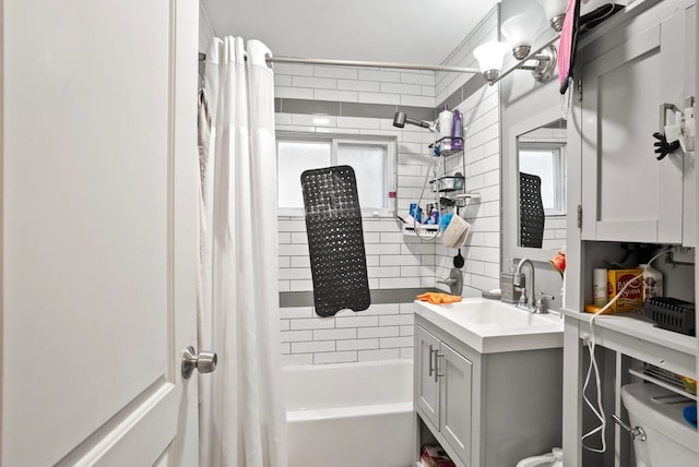 bathroom featuring toilet, shower / bath combo with shower curtain, and vanity