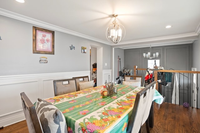 dining space with dark wood-style floors, an inviting chandelier, recessed lighting, ornamental molding, and a decorative wall