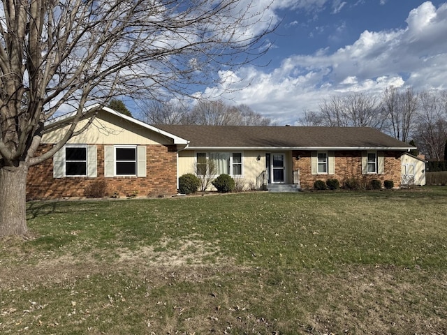 single story home with a storage unit, a front lawn, and brick siding