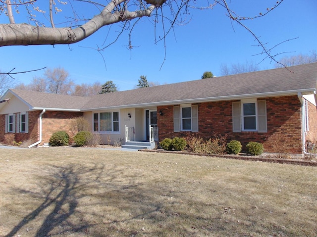ranch-style home with a front yard and brick siding