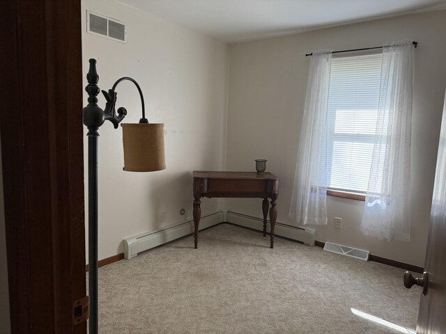 spare room with visible vents, ceiling fan, carpet floors, and a baseboard radiator