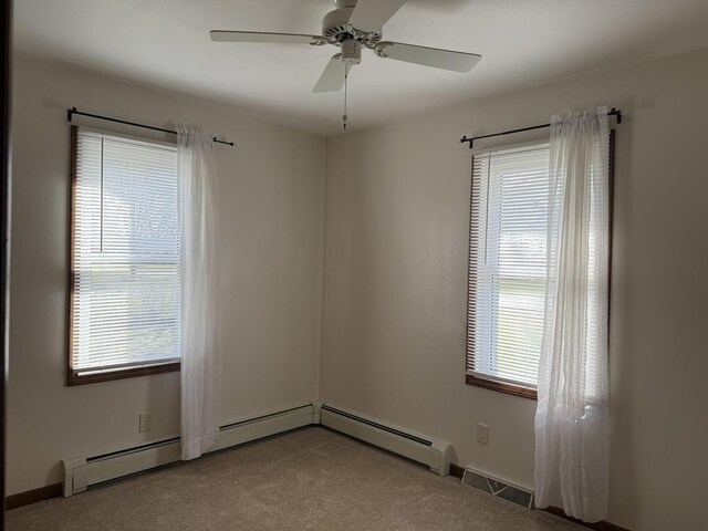 unfurnished bedroom with two closets, carpet flooring, baseboard heating, and baseboards