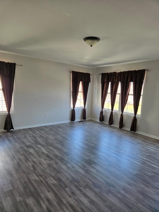 unfurnished room featuring dark wood-style flooring and baseboards