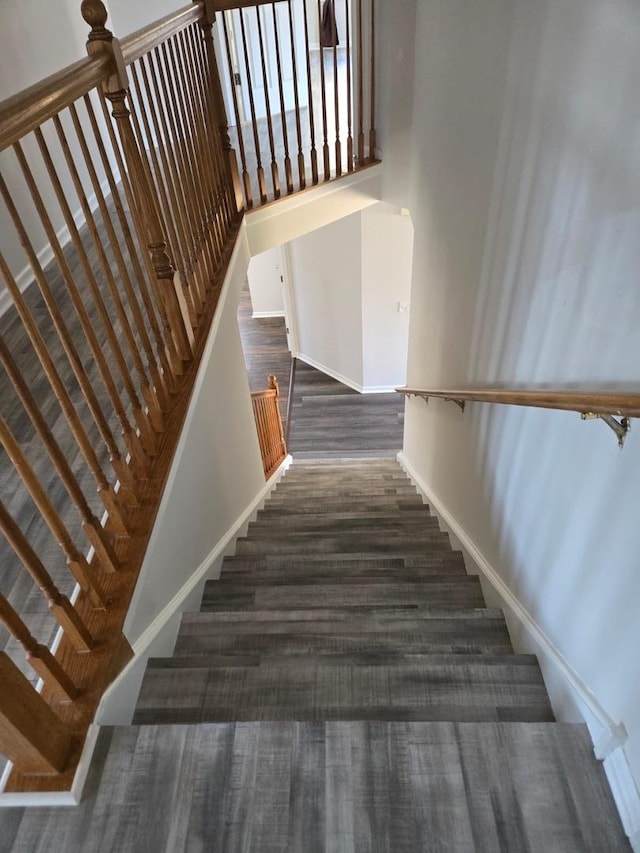 staircase with a high ceiling and baseboards