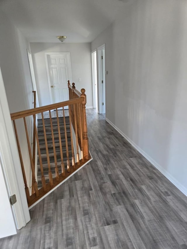 staircase with baseboards and wood finished floors