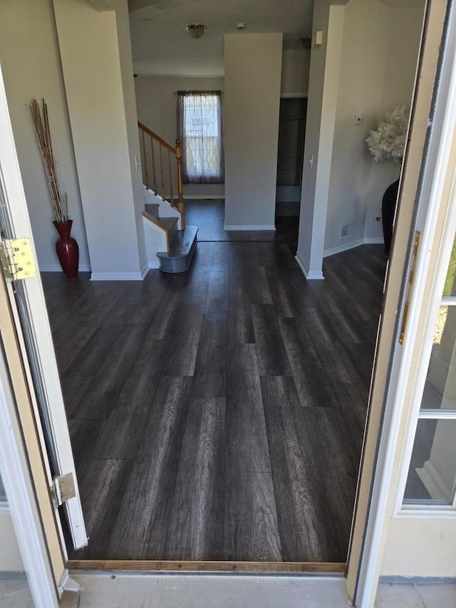 interior space featuring stairs, baseboards, and wood finished floors