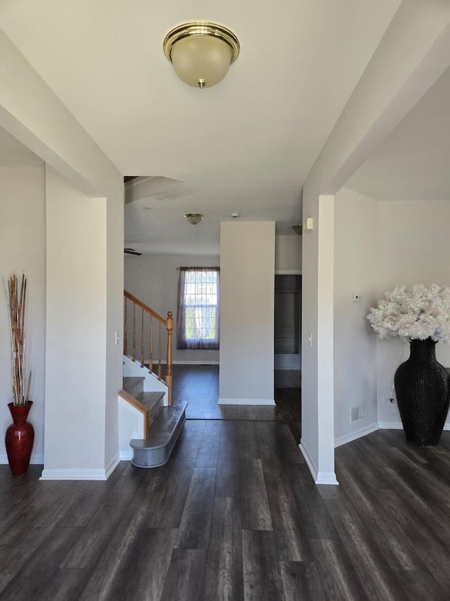 interior space featuring baseboards, stairway, and wood finished floors