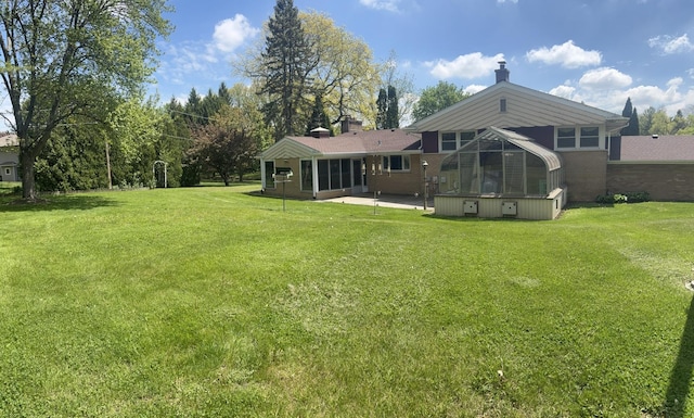 129 Roth Ave, Barrington, IL 60010 - rear view of property featuring a sunroom, a patio, a lawn, and a chimney