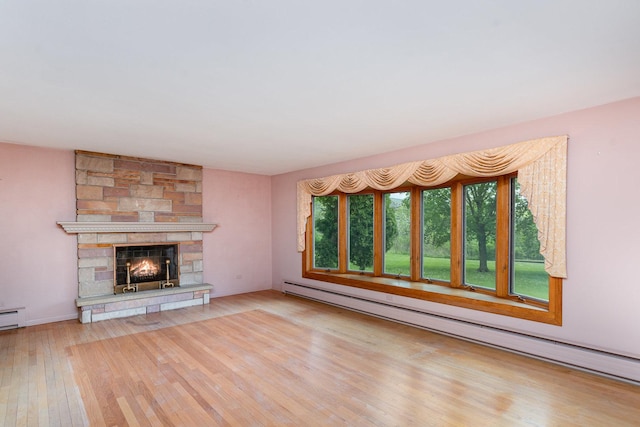 129 Roth Ave, Barrington, IL 60010 - unfurnished living room featuring healthy amount of natural light, a baseboard radiator, wood finished floors, and a stone fireplace