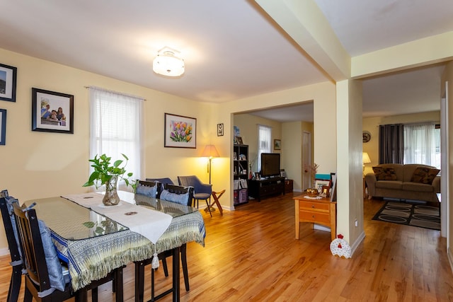 dining area featuring light wood finished floors, a wealth of natural light, and baseboards
